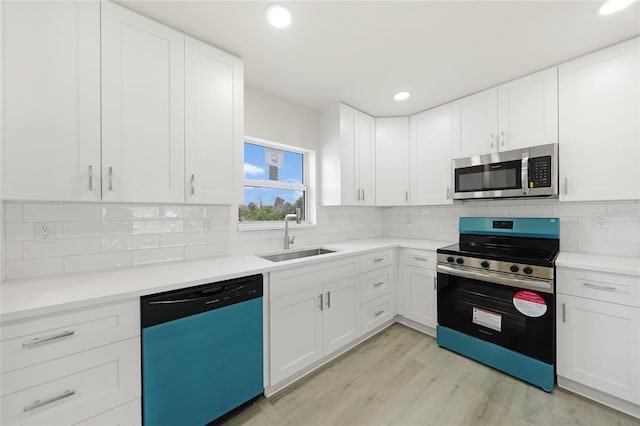 238 Boundary Blvd Unit 3, Rotonda West, FL 33947 - kitchen with appliances with stainless steel finishes, light countertops, white cabinets, light wood-style flooring, and tasteful backsplash