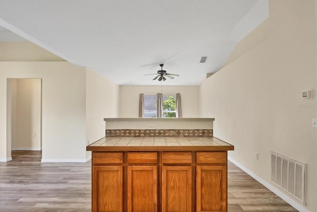 3768 Billingham Ln, North Port, FL 34288 - kitchen featuring tile counters, ceiling fan, light wood finished floors, and decorative backsplash
