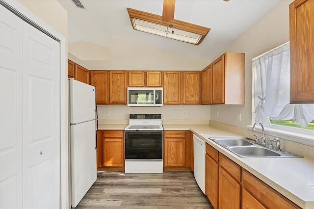 3768 Billingham Ln, North Port, FL 34288 - kitchen featuring white appliances, lofted ceiling, light wood finished floors, light countertops, and brown cabinetry