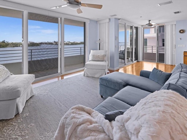 8041 Bay Pointe Dr, Englewood, FL 34224 - living room featuring ceiling fan, wood finished floors, and a water view