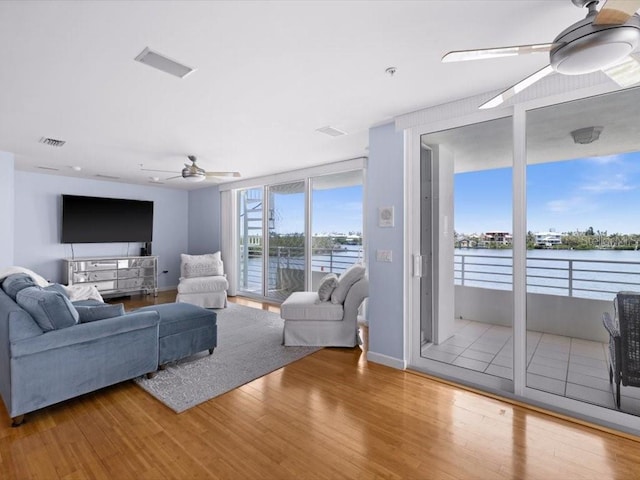 8041 Bay Pointe Dr, Englewood, FL 34224 - living area featuring a ceiling fan, wood finished floors, and a water view