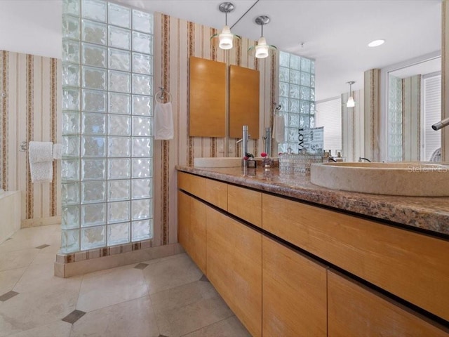 8041 Bay Pointe Dr, Englewood, FL 34224 - full bath featuring wallpapered walls, vanity, a walk in shower, and tile patterned flooring