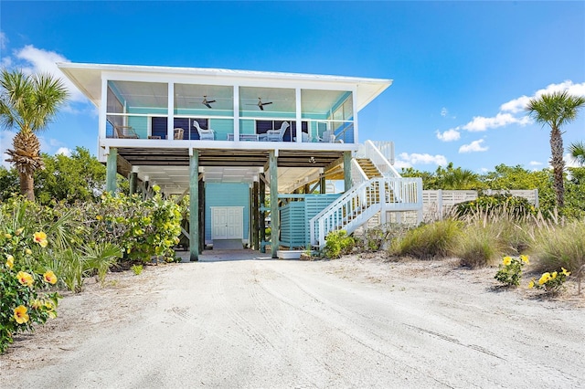 100 S Gulf Blvd, Placida, FL 33946 - raised beach house featuring a ceiling fan, stairs, a carport, and dirt driveway