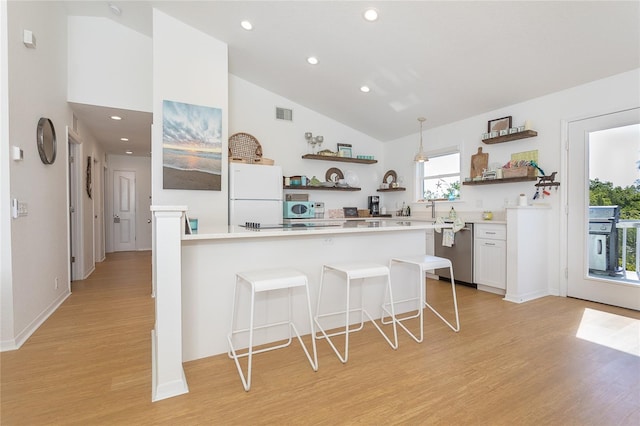 100 S Gulf Blvd, Placida, FL 33946 - kitchen with open shelves, stainless steel appliances, a breakfast bar area, light wood-style floors, and high vaulted ceiling