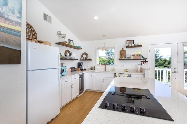 100 S Gulf Blvd, Placida, FL 33946 - kitchen with freestanding refrigerator, open shelves, black electric stovetop, beverage cooler, and white cabinets