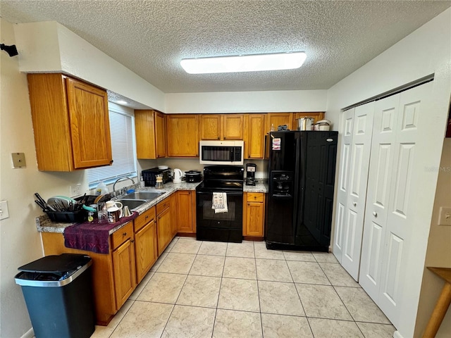 26591 Fairway Dr Unit A & B, Punta Gorda, FL 33982 - kitchen featuring black appliances, brown cabinetry, a textured ceiling, and light tile patterned floors