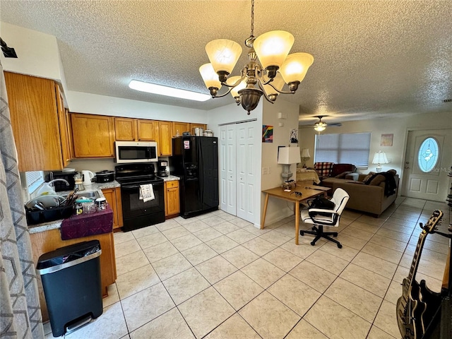 26591 Fairway Dr Unit A & B, Punta Gorda, FL 33982 - kitchen featuring black appliances, a textured ceiling, light tile patterned flooring, brown cabinetry, and a chandelier