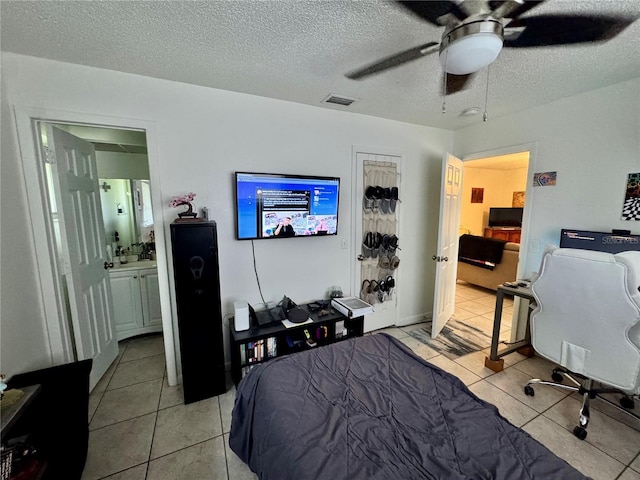 26591 Fairway Dr Unit A & B, Punta Gorda, FL 33982 - bedroom featuring light tile patterned flooring, a textured ceiling, a ceiling fan, and ensuite bath