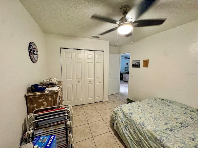 26591 Fairway Dr Unit A & B, Punta Gorda, FL 33982 - bedroom with light tile patterned floors, a closet, a textured ceiling, and a ceiling fan