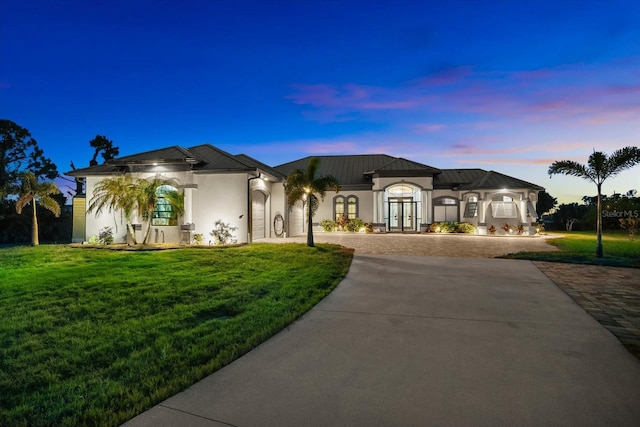 15044 San Domingo Blvd, Port Charlotte, FL 33981 - french country style house featuring curved driveway, french doors, a front yard, stucco siding, and a metal roof