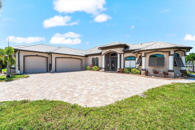 15044 San Domingo Blvd, Port Charlotte, FL 33981 - view of front of house with a standing seam roof, stucco siding, an attached garage, and decorative driveway