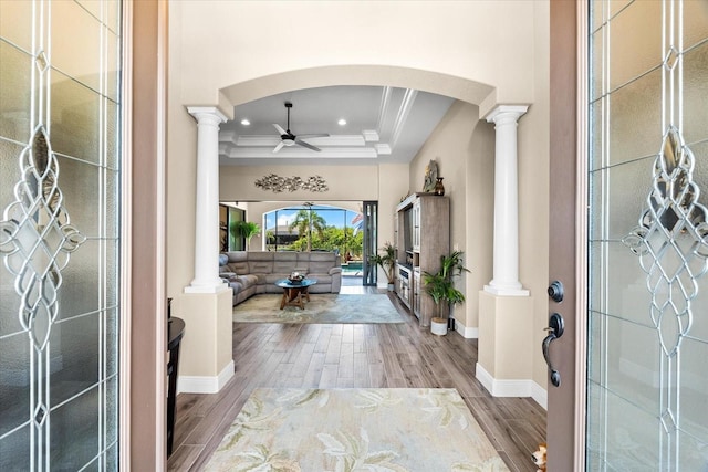 15044 San Domingo Blvd, Port Charlotte, FL 33981 - entrance foyer featuring a ceiling fan, wood finished floors, ornamental molding, arched walkways, and a tray ceiling
