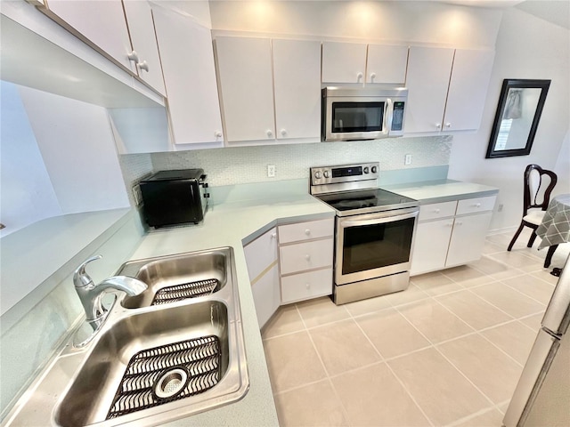 11644 SW Egret Cir Unit 905, Lake Suzy, FL 34269 - kitchen featuring stainless steel appliances, light countertops, tasteful backsplash, light tile patterned floors, and white cabinets