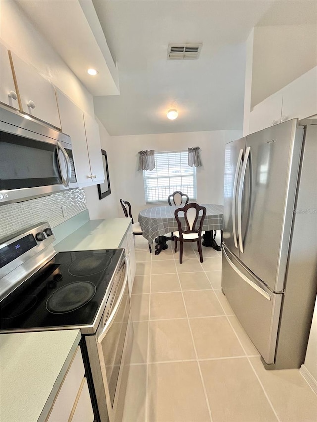 11644 SW Egret Cir Unit 905, Lake Suzy, FL 34269 - kitchen with stainless steel appliances, light countertops, light tile patterned floors, backsplash, and white cabinets