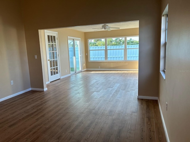 unfurnished room featuring dark hardwood / wood-style flooring, a healthy amount of sunlight, and ceiling fan