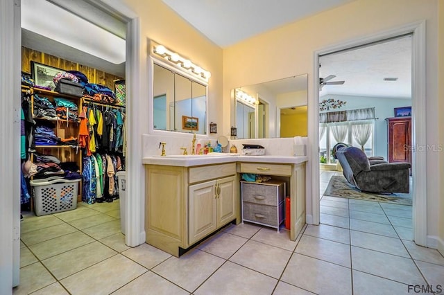 bathroom with vaulted ceiling, tile patterned floors, and vanity