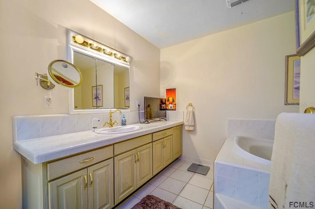 bathroom featuring tile patterned flooring, tiled tub, and vanity