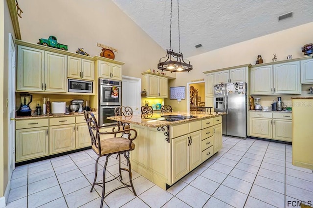 kitchen with pendant lighting, appliances with stainless steel finishes, light tile patterned flooring, and an island with sink