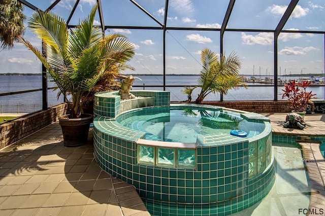 exterior space featuring an in ground hot tub, a water view, a patio, and a lanai