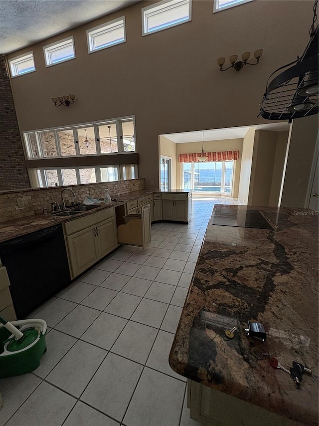 kitchen with sink, dishwasher, a high ceiling, light tile patterned flooring, and kitchen peninsula