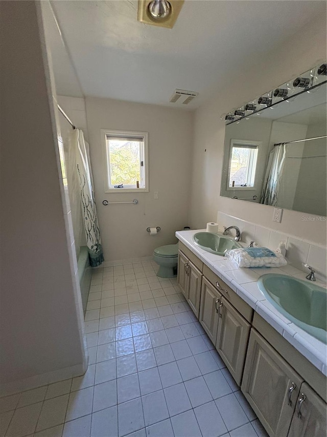 full bathroom featuring vanity, toilet, tile patterned flooring, and shower / bath combo