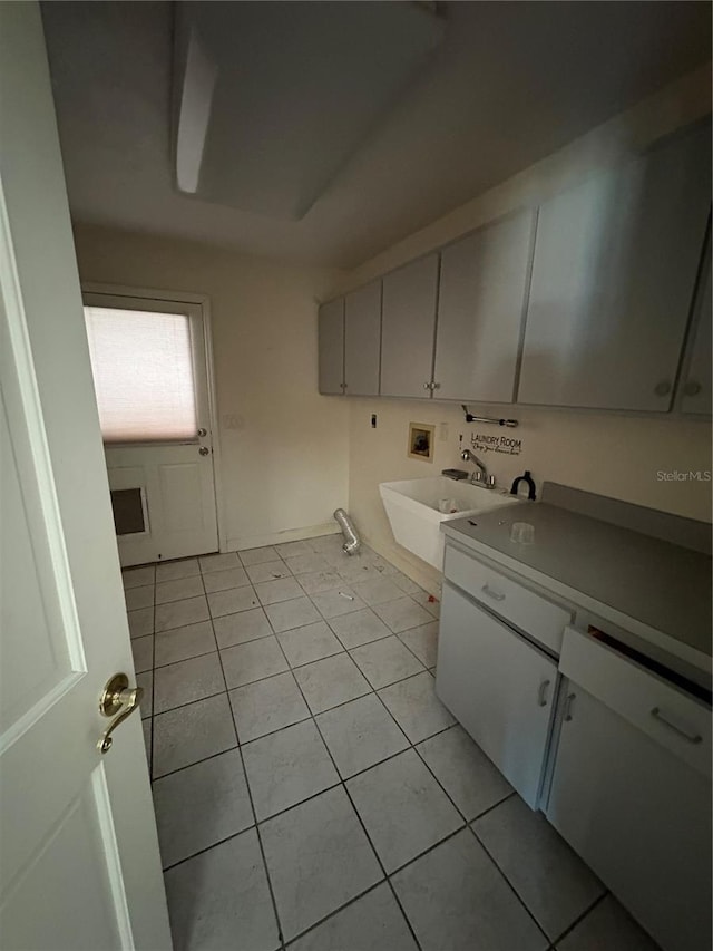 kitchen featuring light tile patterned flooring, white cabinetry, and sink