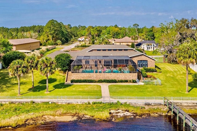 rear view of property with a lanai and a water view