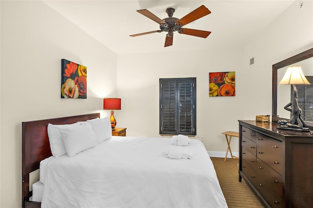 bedroom featuring ceiling fan and dark colored carpet