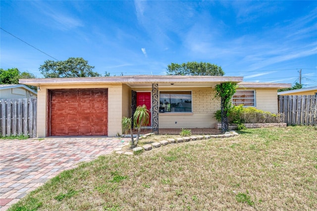 ranch-style house featuring a front lawn and a garage