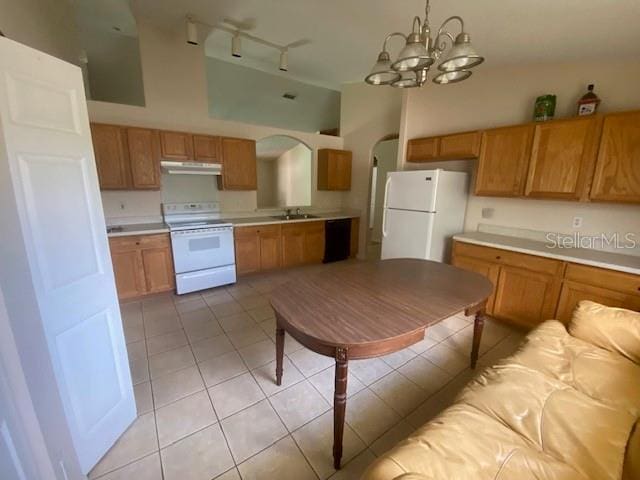 kitchen with a notable chandelier, light tile floors, white appliances, track lighting, and sink