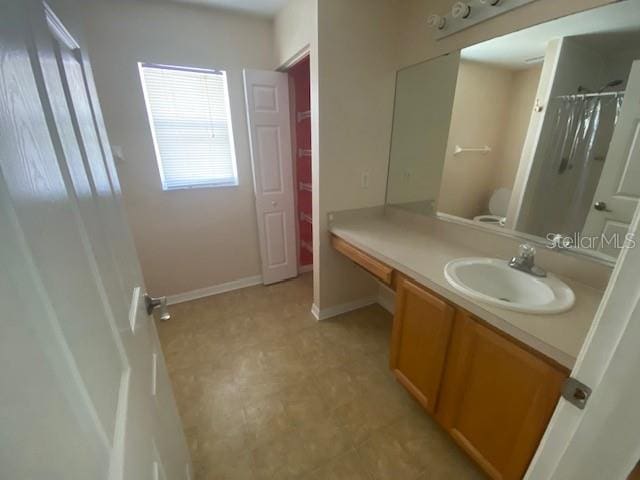 bathroom featuring toilet, vanity, and tile flooring