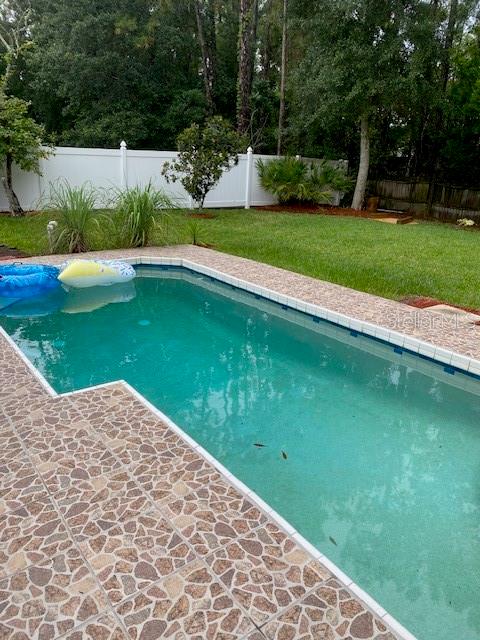 view of swimming pool with a lawn