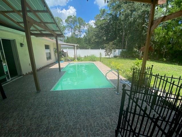 view of swimming pool with a patio area and a yard