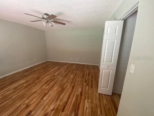 empty room featuring hardwood / wood-style floors, a textured ceiling, and ceiling fan