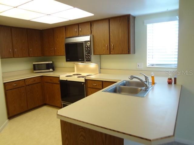 kitchen featuring white electric range oven and sink