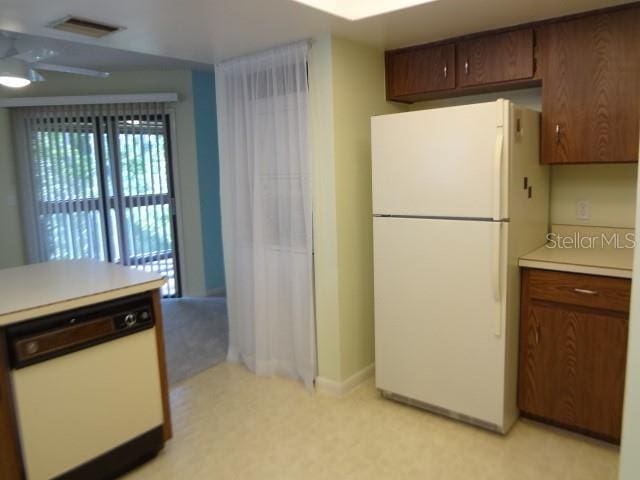 kitchen featuring white appliances and light tile flooring