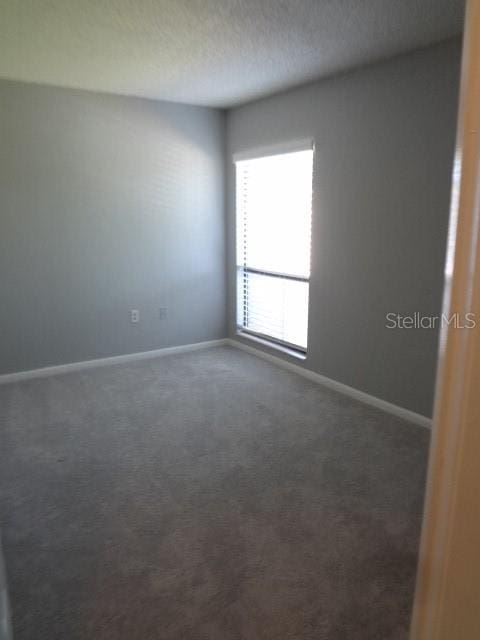 carpeted spare room featuring a textured ceiling