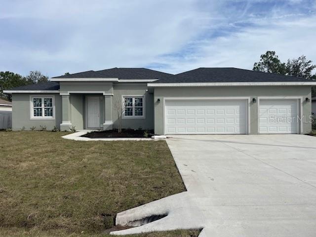 view of front of property featuring a front yard and a garage