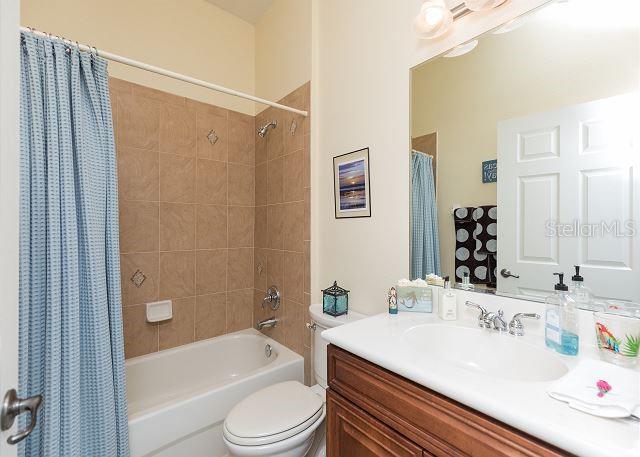 full bathroom featuring shower / bath combo, toilet, and vanity