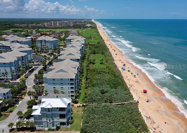 drone / aerial view featuring a water view and a view of the beach