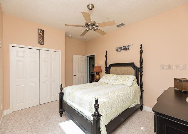 carpeted bedroom featuring a closet and ceiling fan