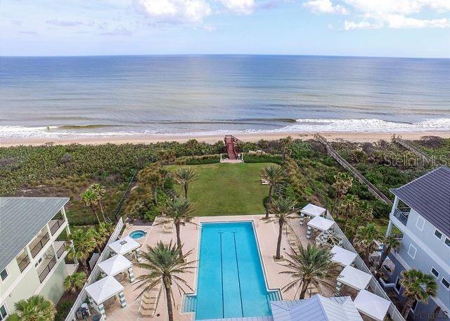 drone / aerial view with a water view and a beach view