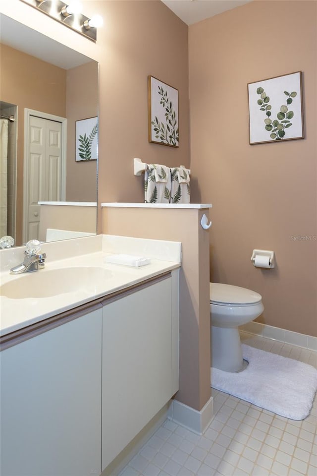 bathroom featuring tile patterned floors, vanity, and toilet