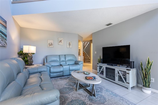 tiled living room featuring a textured ceiling