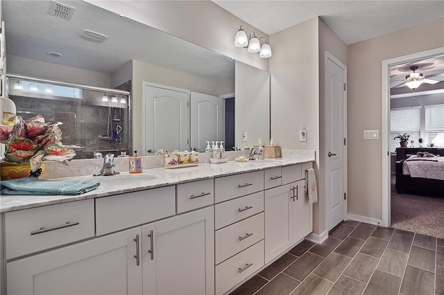 bathroom featuring a textured ceiling, vanity, a shower with door, and ceiling fan