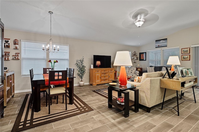 living room featuring ceiling fan with notable chandelier and lofted ceiling