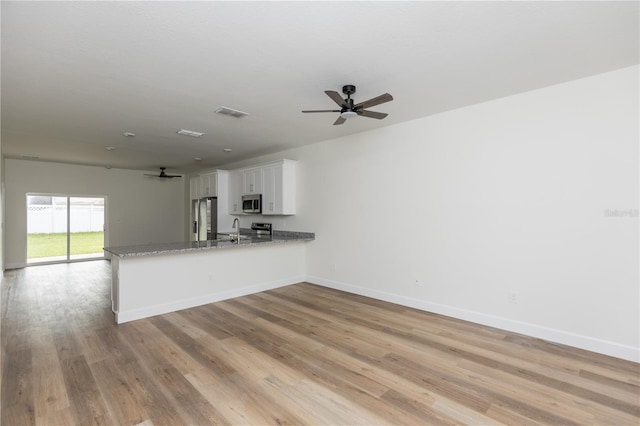 kitchen with stainless steel appliances, light hardwood / wood-style floors, white cabinets, kitchen peninsula, and ceiling fan