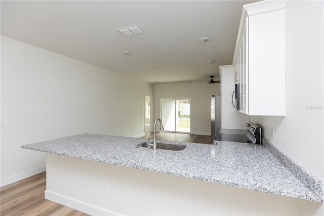 kitchen featuring light hardwood / wood-style floors, sink, appliances with stainless steel finishes, light stone countertops, and white cabinets