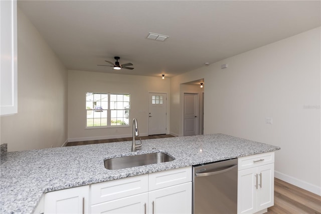 kitchen featuring light stone counters, sink, light hardwood / wood-style floors, white cabinets, and dishwasher