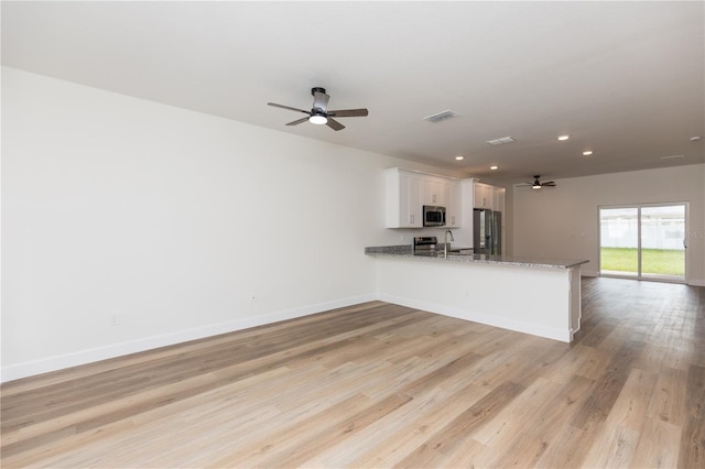 interior space featuring light wood-type flooring, sink, and ceiling fan